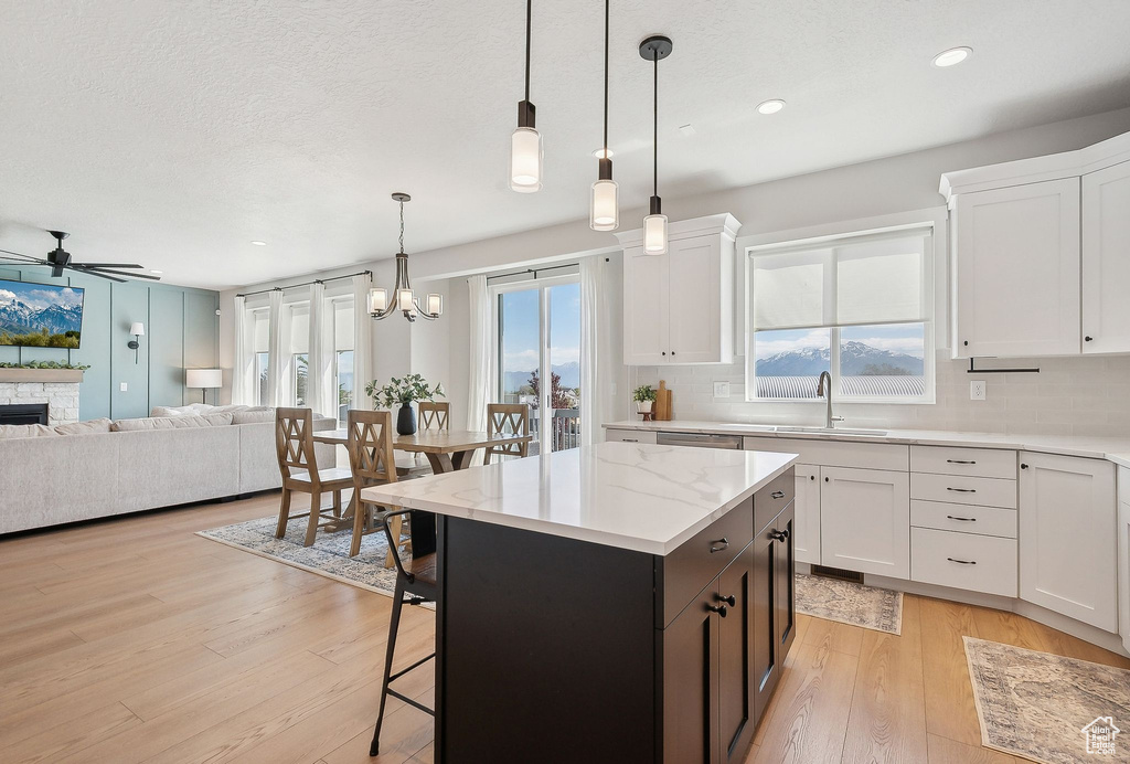 Kitchen featuring open floor plan, a ceiling fan, decorative backsplash, white cabinetry, and recessed lighting