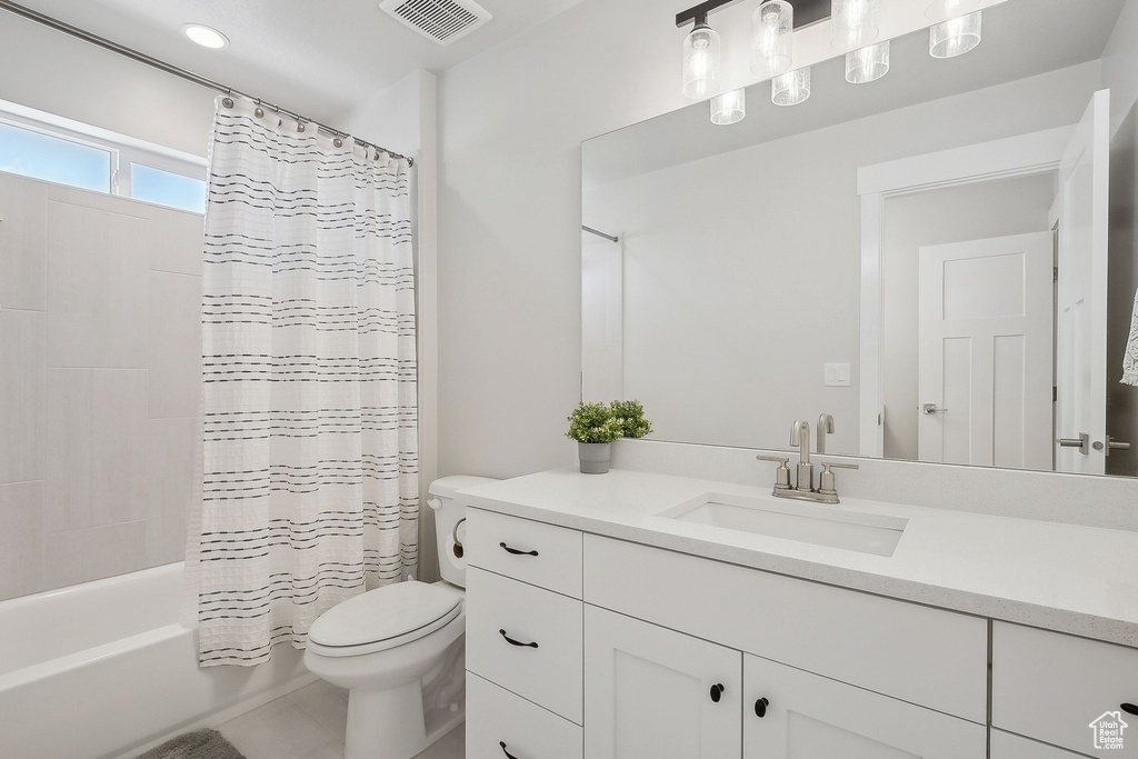 Full bath featuring toilet, vanity, and shower / bath combo