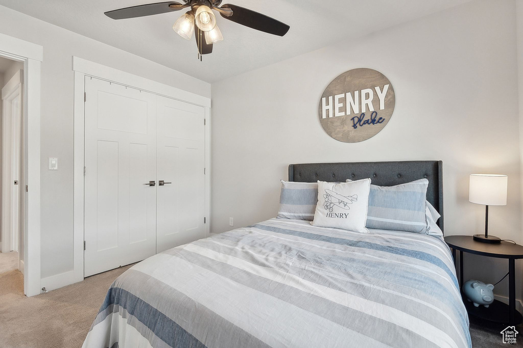 Carpeted bedroom with a closet and ceiling fan