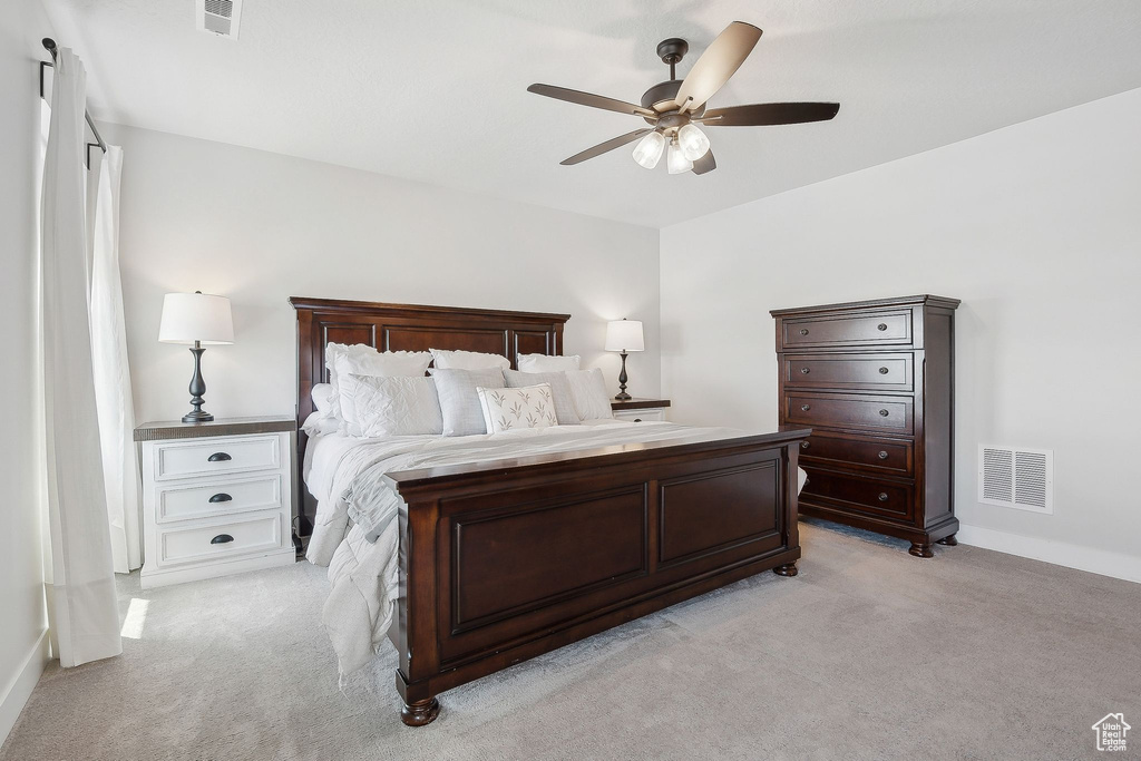Bedroom with light carpet, a ceiling fan, and baseboards