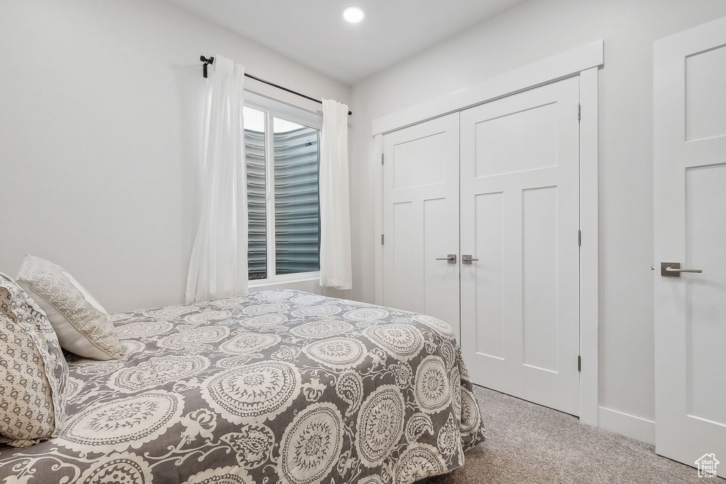 Carpeted bedroom with a closet and baseboards