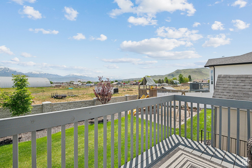 Wooden deck with a mountain view and a yard