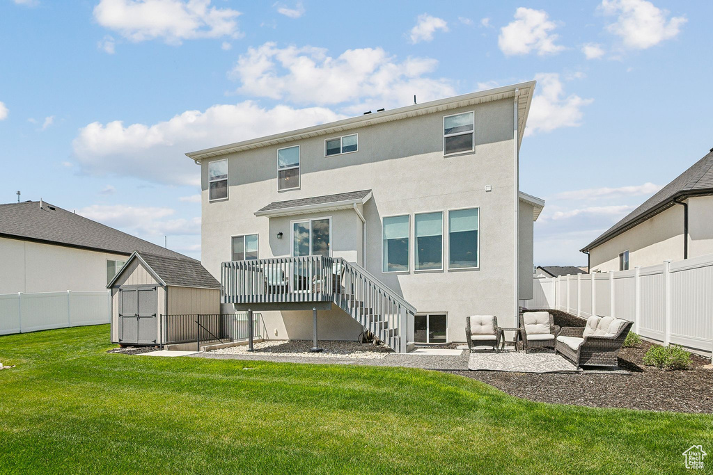Back of house featuring an outdoor living space, a wooden deck, stucco siding, a patio area, and stairs