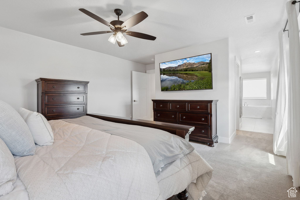 Bedroom featuring light carpet, baseboards, and ceiling fan
