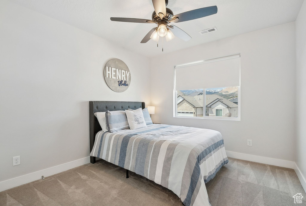 Carpeted bedroom with baseboards and a ceiling fan