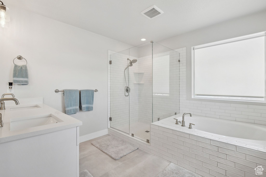 Bathroom with a bath, a stall shower, double vanity, and tile patterned floors