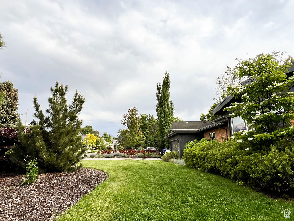 View of green lawn featuring a garage