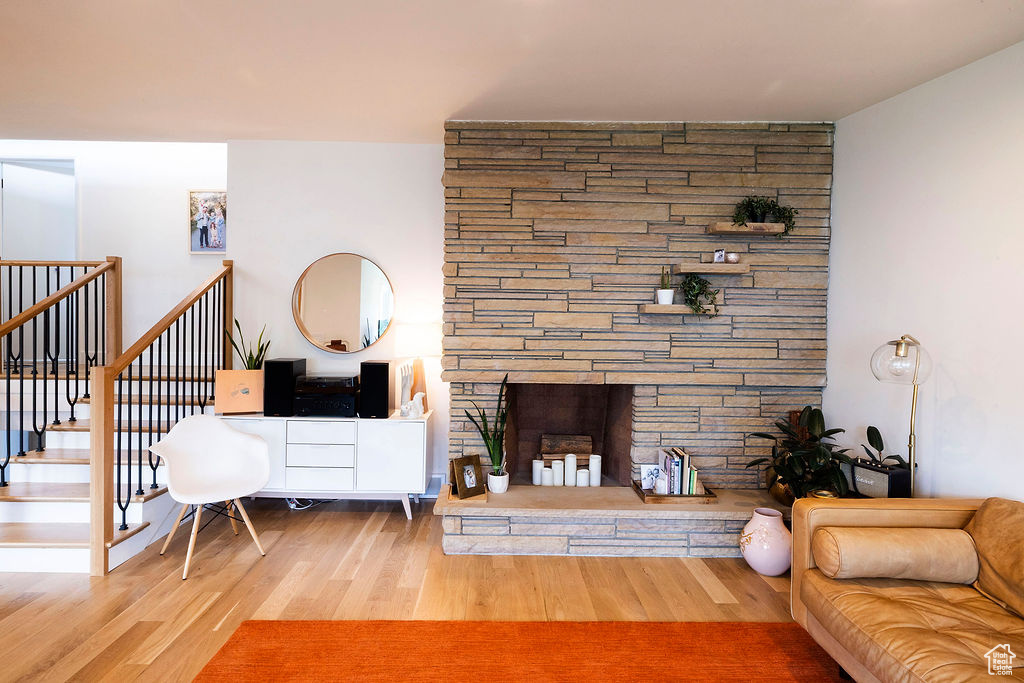 Living room featuring a fireplace, wood finished floors, and stairs