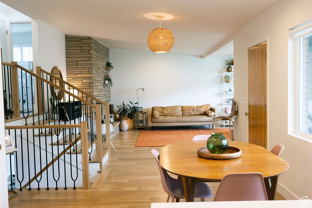 Dining room with light wood-style flooring and stairs