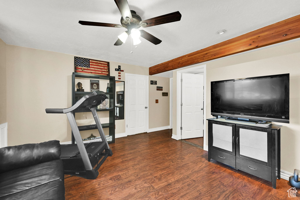 Exercise area with ceiling fan, wood finished floors, and baseboards