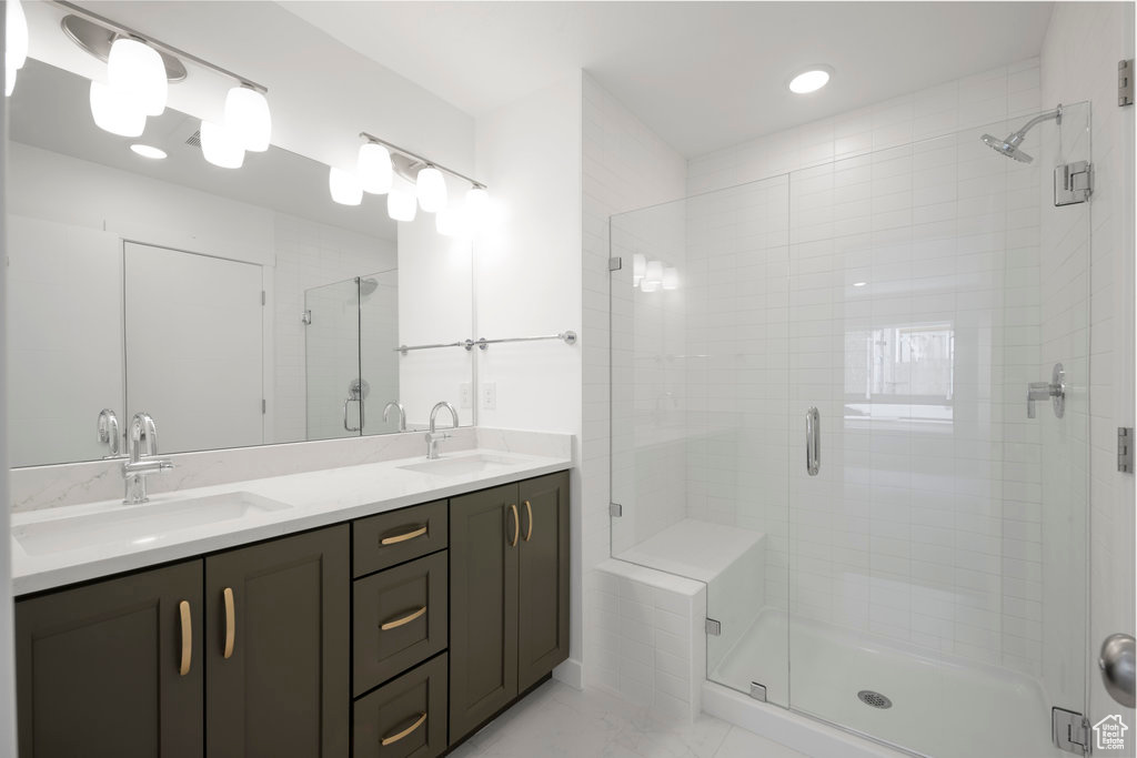 Bathroom with a stall shower, double vanity, marble finish flooring, and recessed lighting