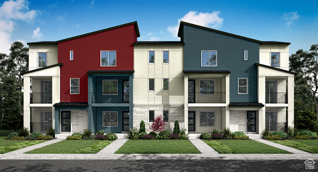 Townhome / multi-family property featuring a front yard and stone siding