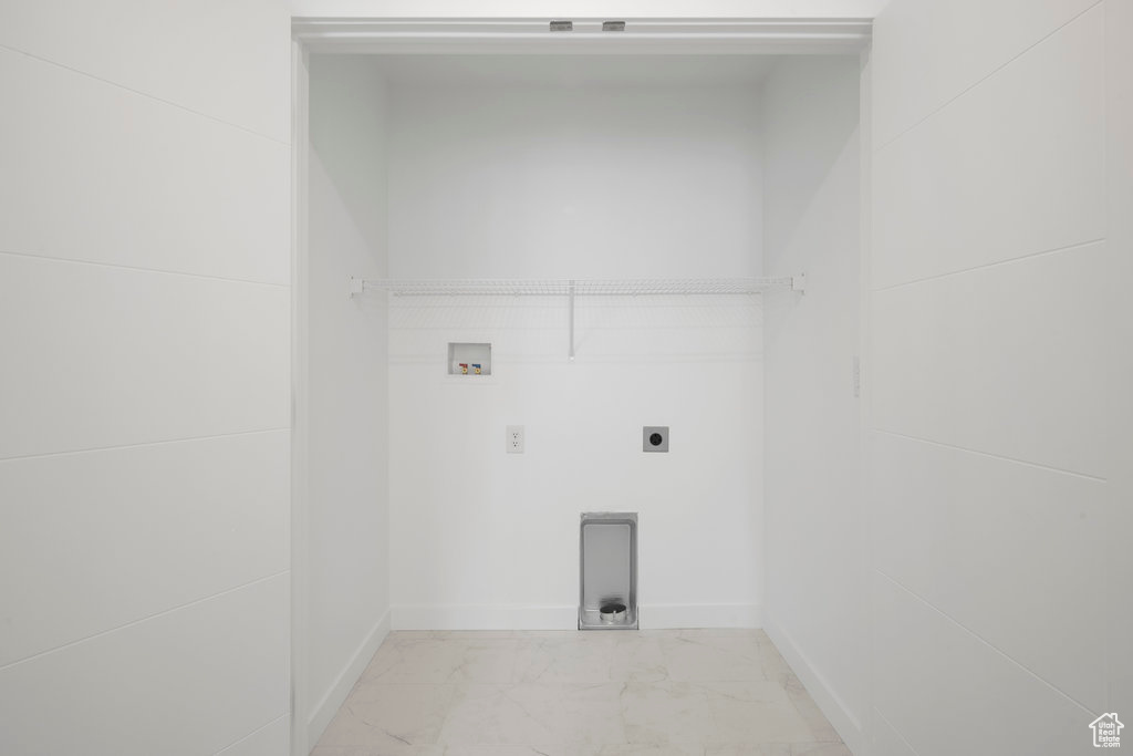 Laundry area featuring electric dryer hookup, hookup for a washing machine, light marble finish flooring, and baseboards