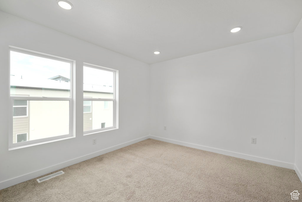 Empty room featuring carpet floors, baseboards, and recessed lighting