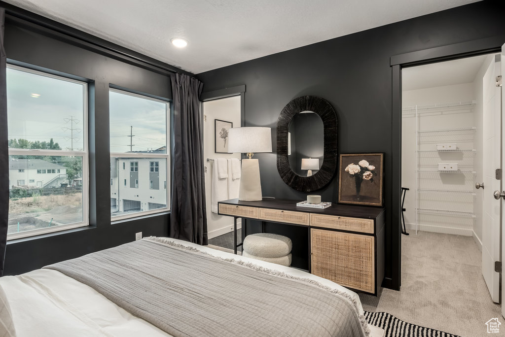 Bedroom with light colored carpet and baseboards