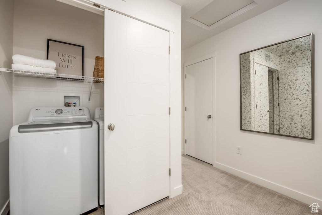 Laundry room featuring light carpet, independent washer and dryer, attic access, and baseboards