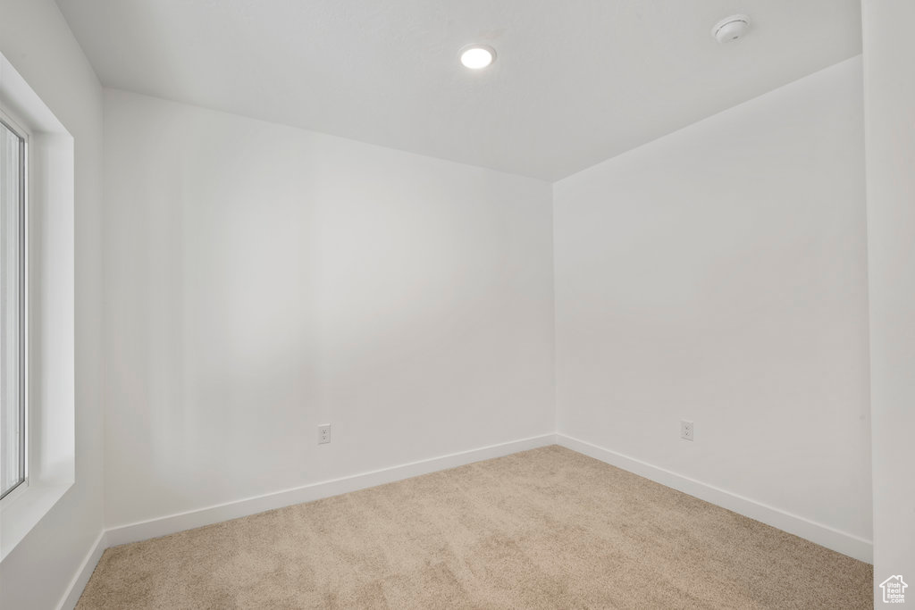 Carpeted empty room with baseboards, recessed lighting, and a smoke detector