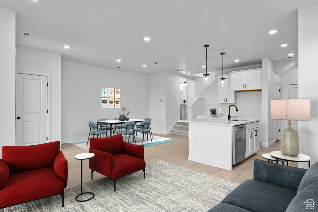 Living area with recessed lighting, stairs, light wood-style flooring, and baseboards