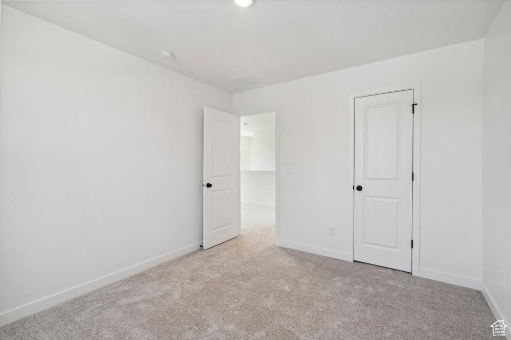 Unfurnished bedroom featuring carpet and baseboards