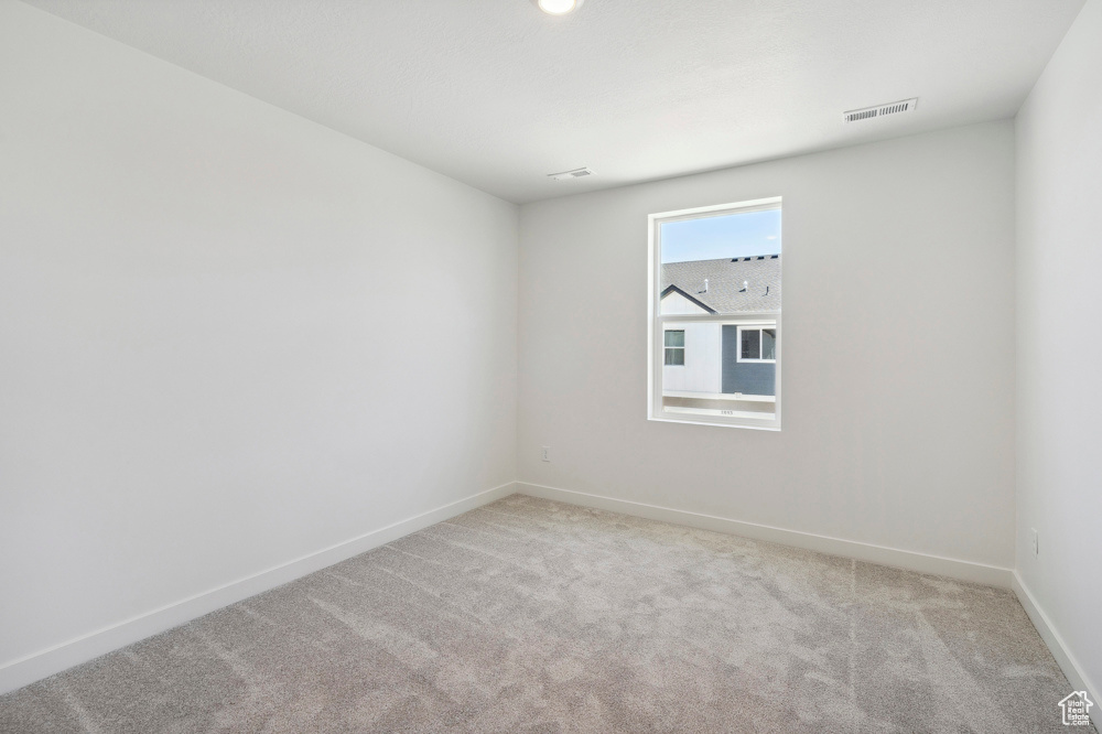 Unfurnished room with light carpet and baseboards