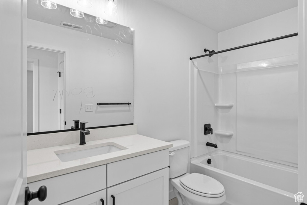 Bathroom featuring vanity, toilet, and shower / tub combination