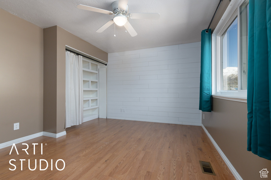 Unfurnished bedroom featuring wood finished floors, ceiling fan, and baseboards