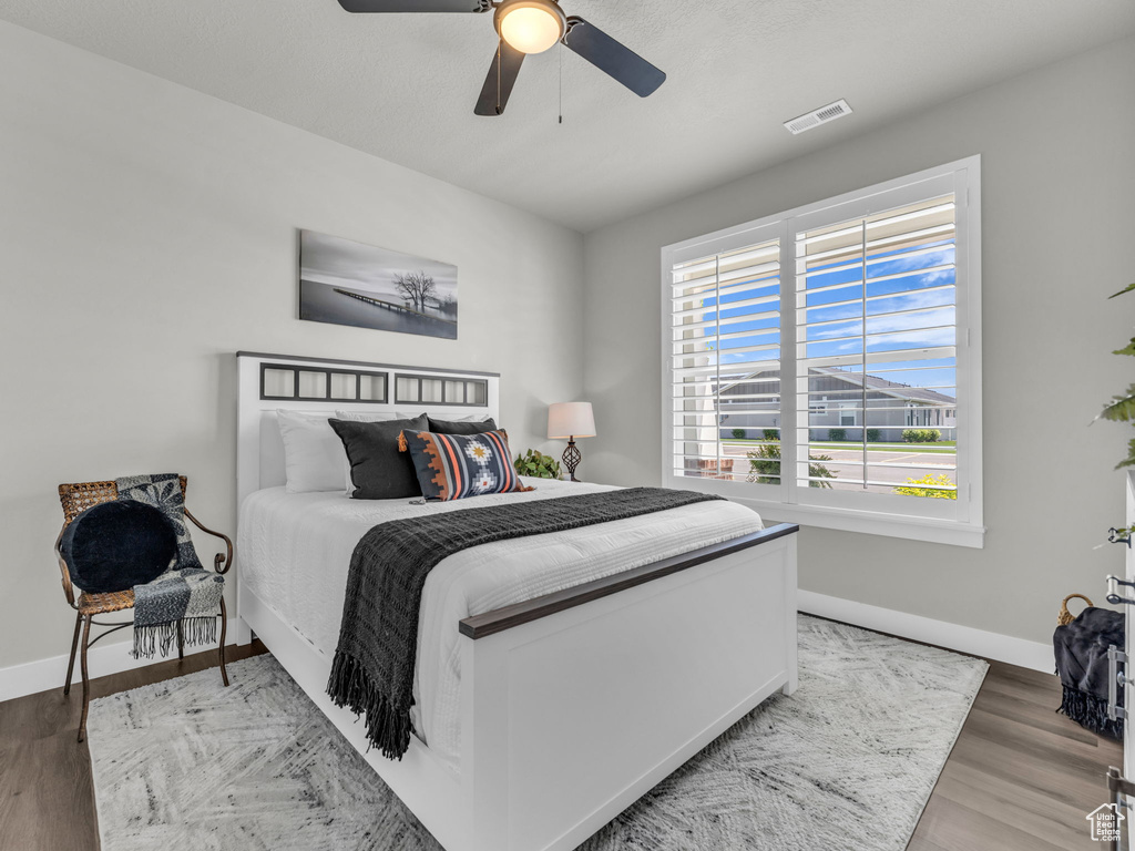 Bedroom with baseboards, wood finished floors, and ceiling fan