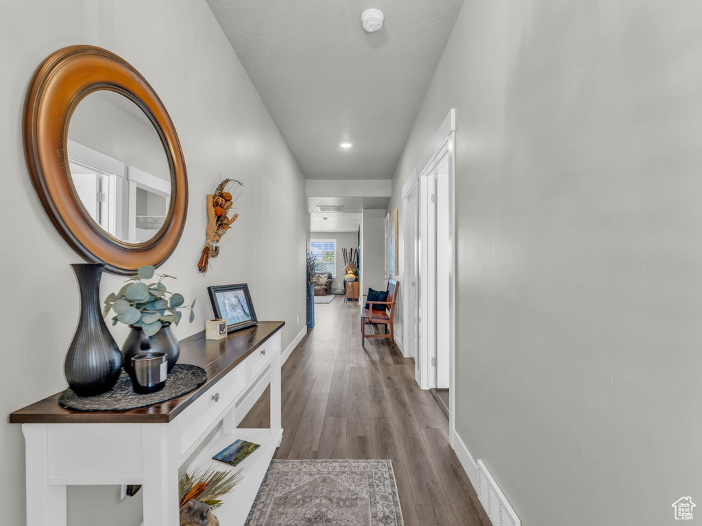 Corridor featuring wood finished floors, recessed lighting, and baseboards