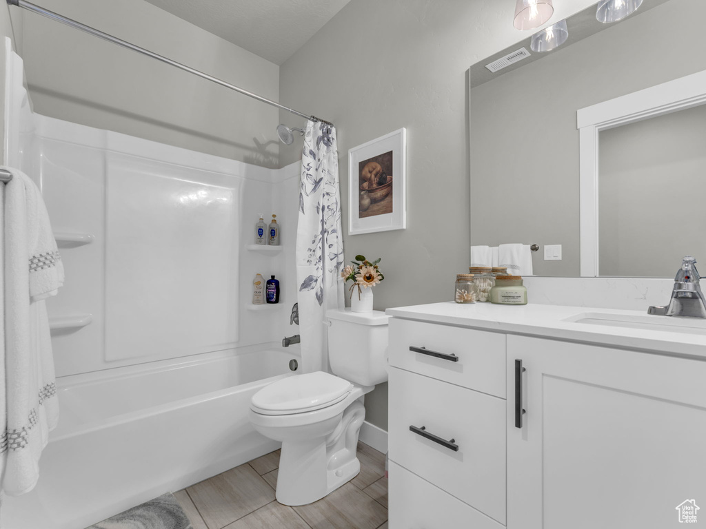Full bath featuring toilet, vanity, and shower / bathtub combination with curtain