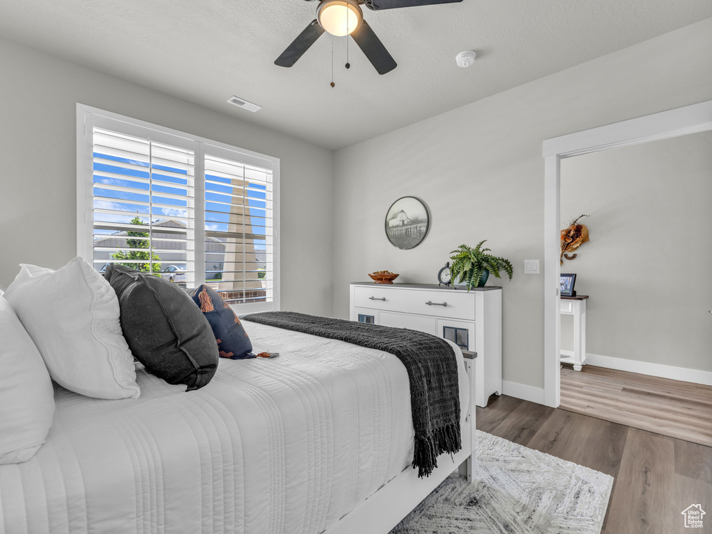 Bedroom featuring wood finished floors, baseboards, and ceiling fan