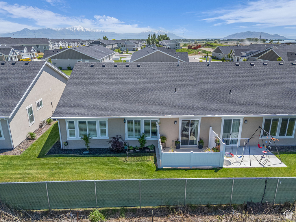Rear view of house featuring a patio area, a mountain view, stucco siding, and roof with shingles