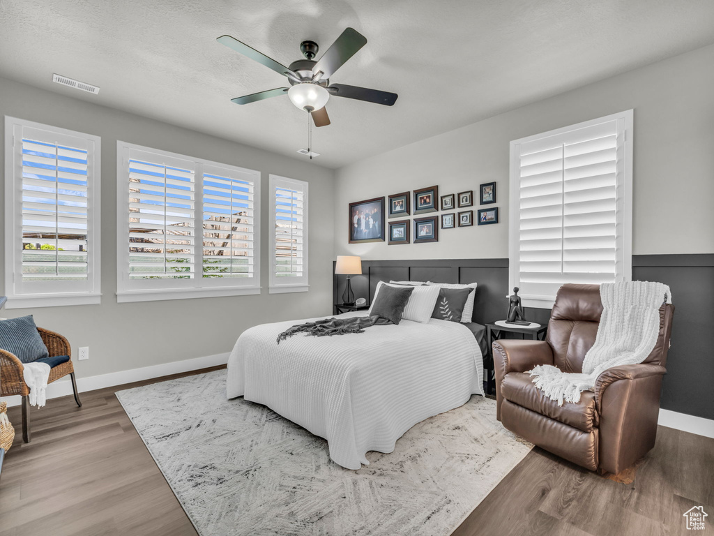 Bedroom featuring wood finished floors, baseboards, and a ceiling fan