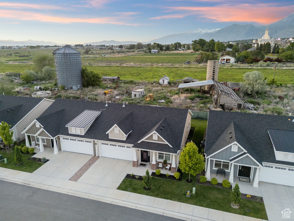 Aerial view of property and surrounding area featuring a mountainous background