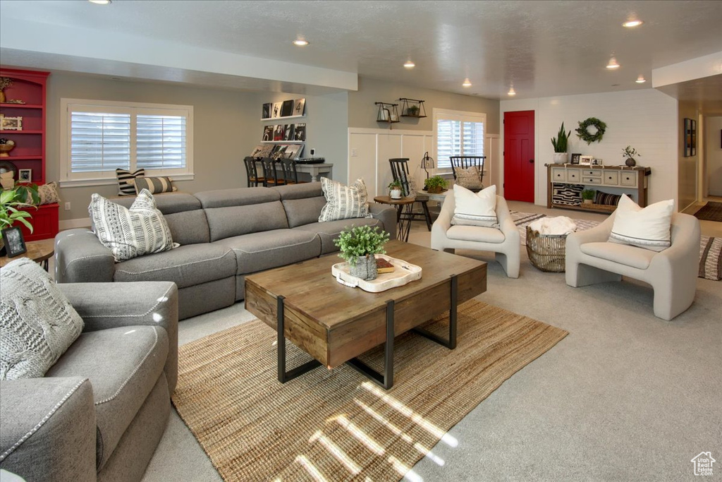 Living area with recessed lighting and light carpet
