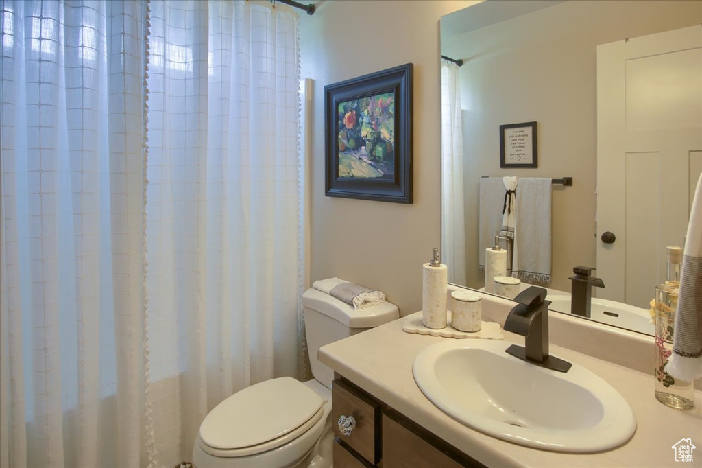 Full bathroom featuring toilet, vanity, and a shower with shower curtain