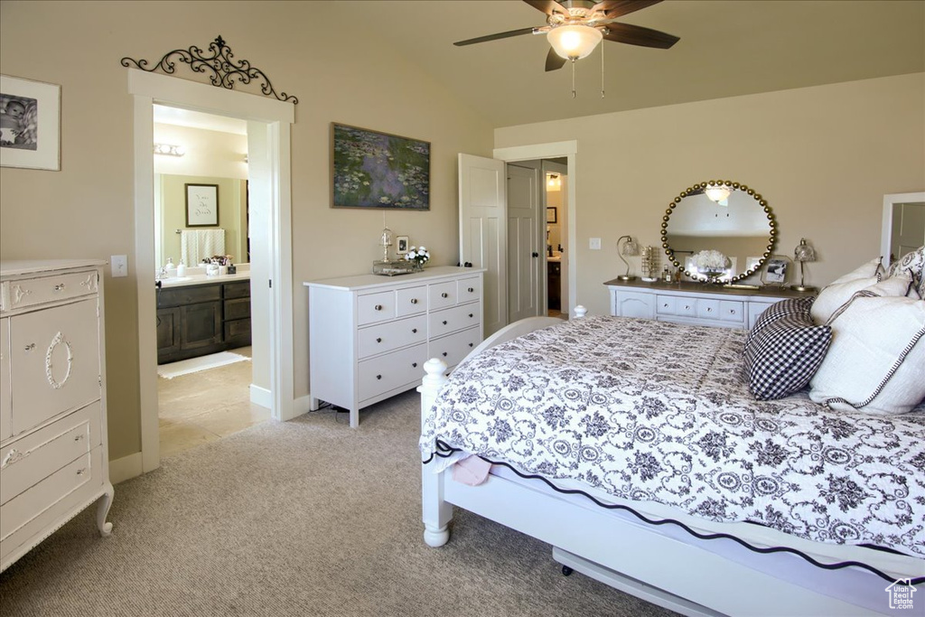 Bedroom featuring light colored carpet, vaulted ceiling, and ensuite bathroom