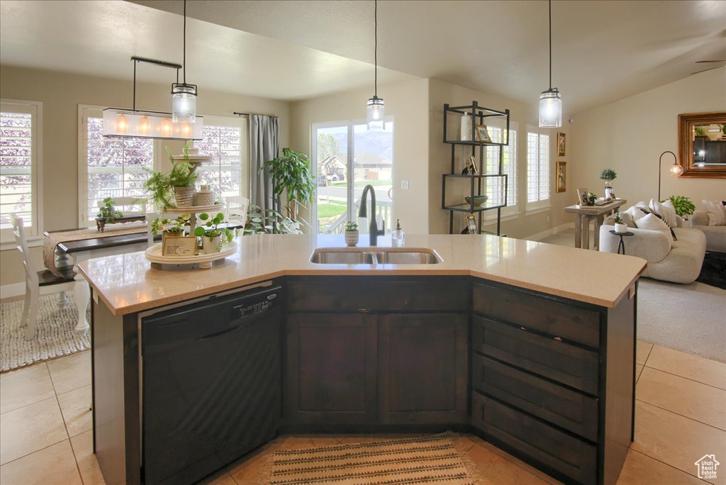 Kitchen featuring dishwasher, a sink, open floor plan, light countertops, and light tile patterned flooring