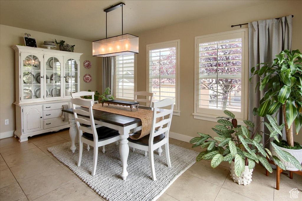 Dining space featuring light tile patterned floors and baseboards
