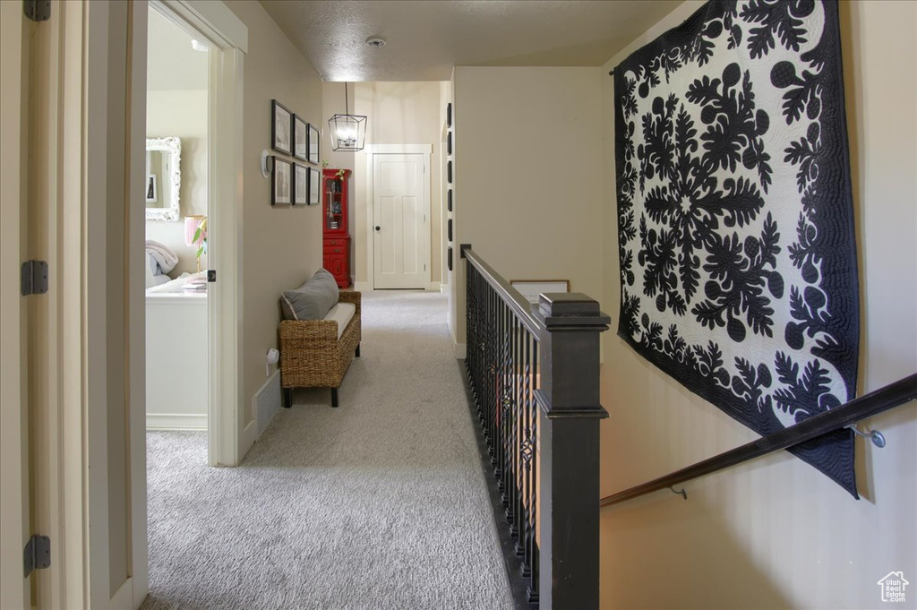 Hallway with an upstairs landing and carpet