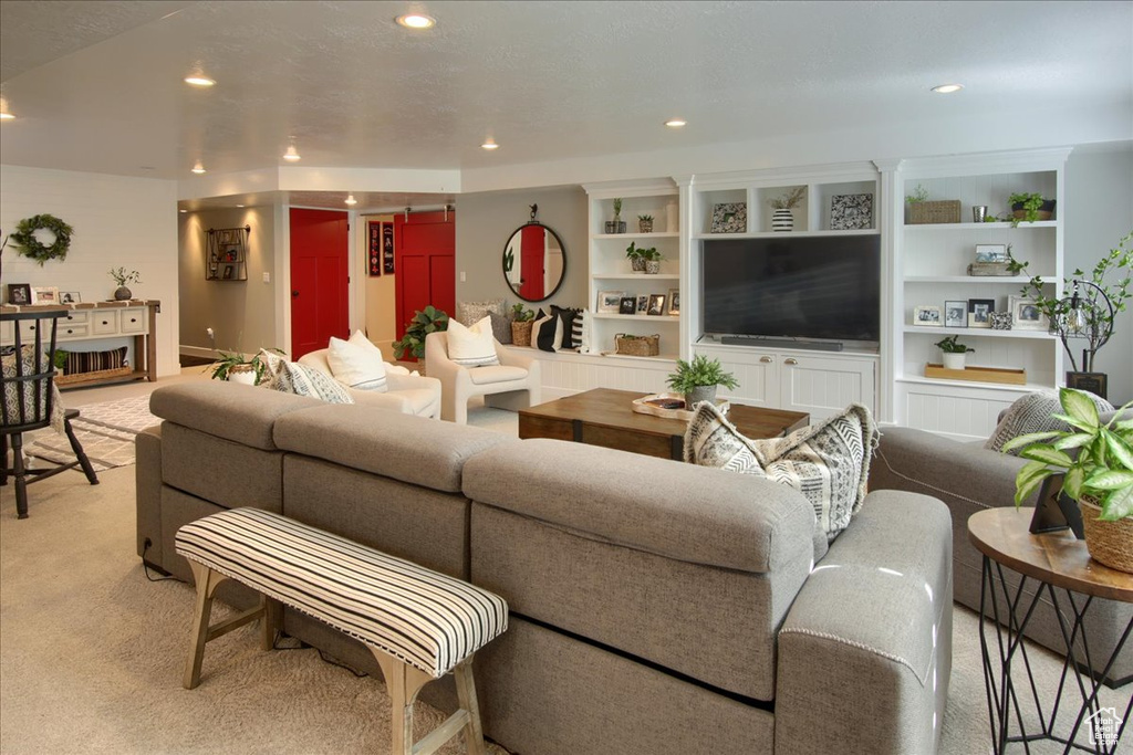 Living area featuring light colored carpet and recessed lighting