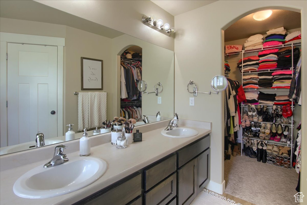 Full bathroom featuring double vanity and a walk in closet