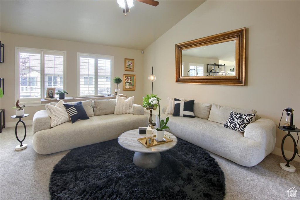 Living area with carpet, a ceiling fan, vaulted ceiling, and baseboards