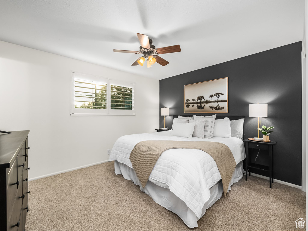 Carpeted bedroom featuring baseboards and ceiling fan
