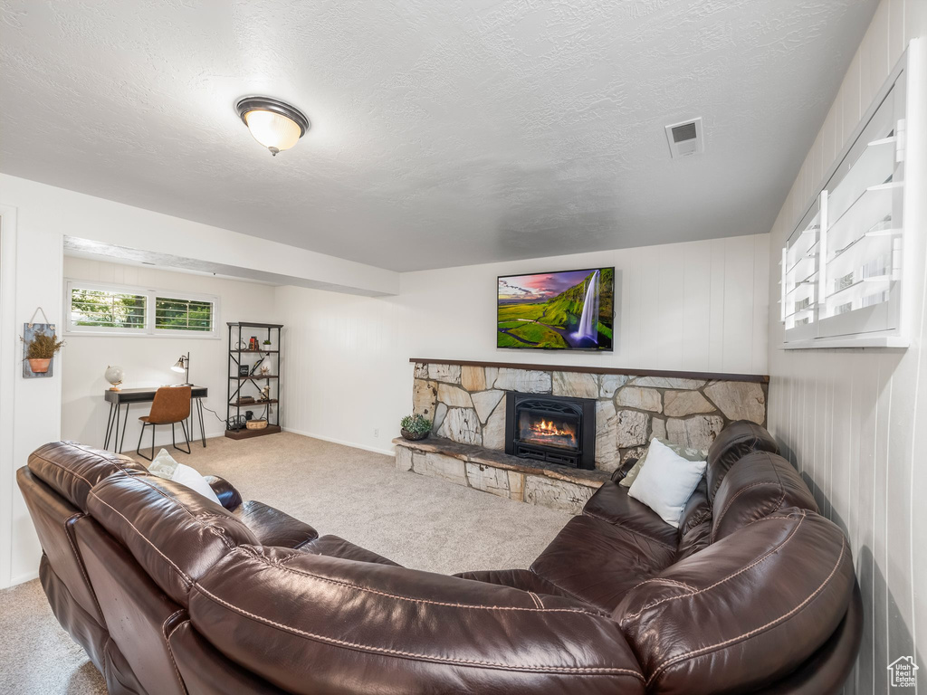 Carpeted living area with a fireplace and a textured ceiling