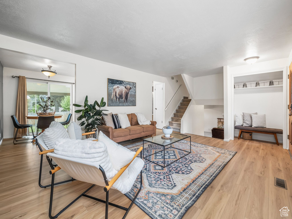 Living room featuring stairs and light wood-style floors