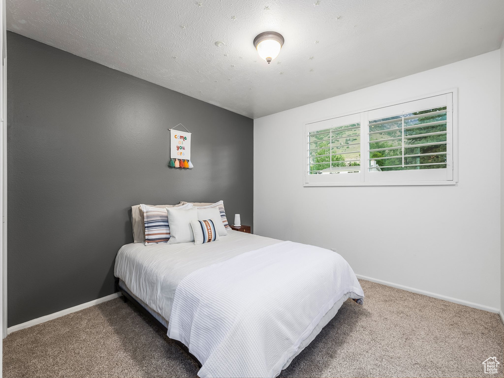 Bedroom featuring carpet floors and baseboards