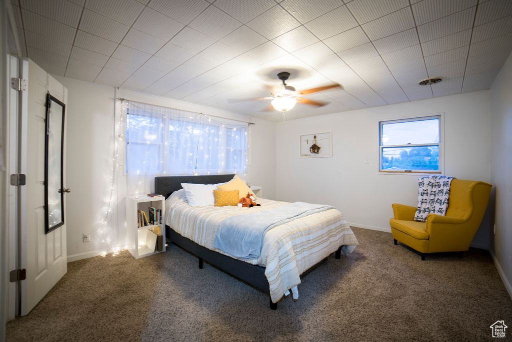 Carpeted bedroom featuring baseboards and a ceiling fan