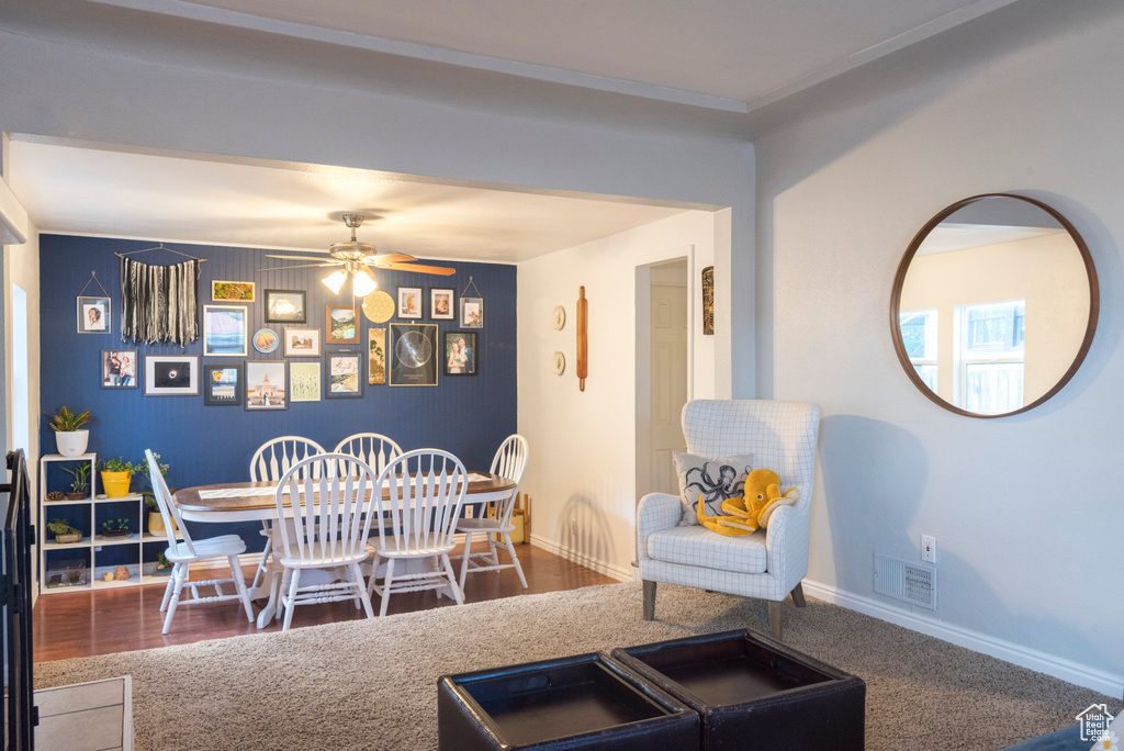 Dining area featuring an accent wall, a ceiling fan, and baseboards