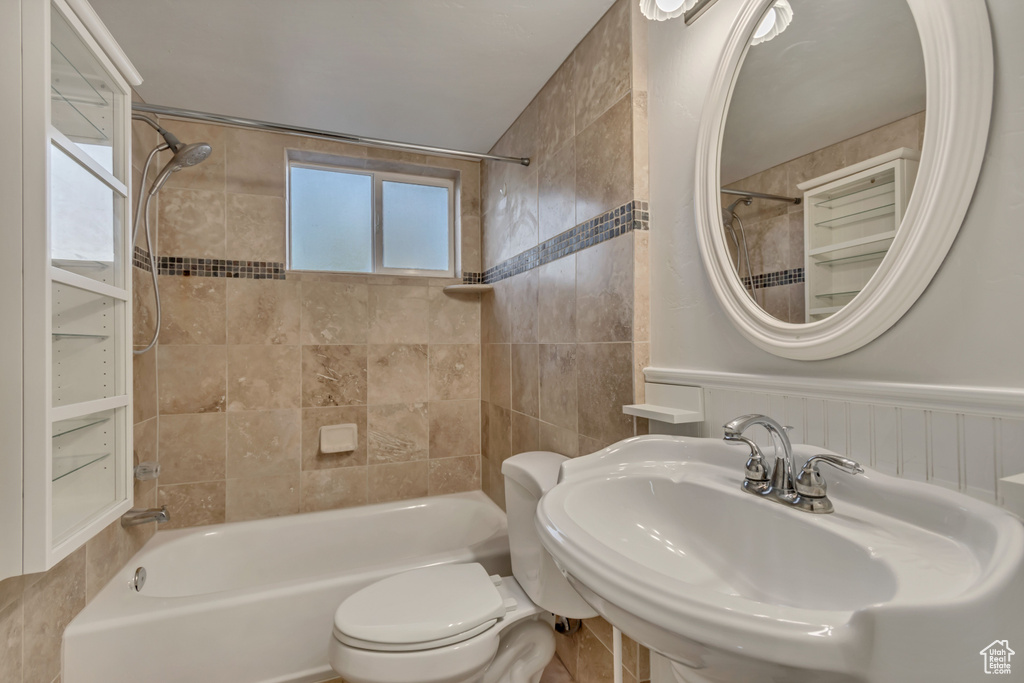 Full bathroom with shower / bath combination with curtain, a sink, and toilet