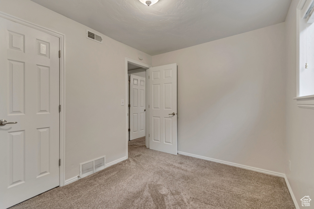 Unfurnished bedroom with carpet flooring and baseboards